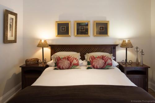 a bedroom with a large bed with two lamps at Carslogie House in Port Elizabeth
