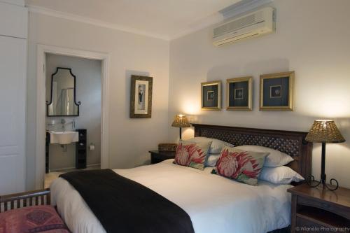 a bedroom with a large white bed with two pillows at Carslogie House in Port Elizabeth