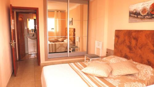 ein Schlafzimmer mit einem Bett und ein Badezimmer mit einem Spiegel in der Unterkunft In Las Americas with amazing view in Playa de las Americas