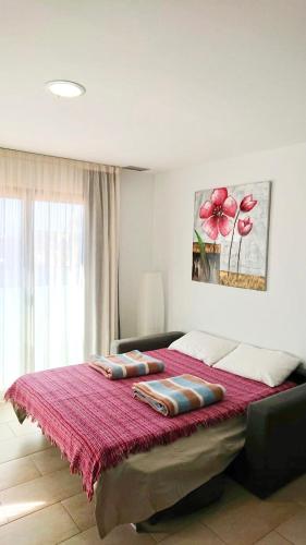 a bedroom with a large bed with a red blanket at Edifici Violetta in Empuriabrava