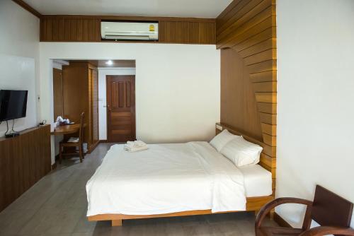a bedroom with a white bed and a desk at Tree Home Plus in Nakhon Si Thammarat