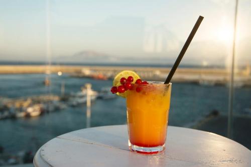 a drink on a table with a view of the water at La Residencia Puerto Hotel & Spa in Tarifa