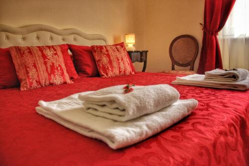 Una cama roja con toallas encima. en WELL COME - Santa Lucia en Nápoles