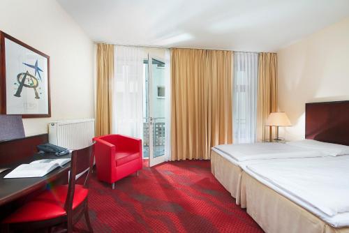 a hotel room with a large bed and a desk and a desk at SORAT Hotel Cottbus in Cottbus