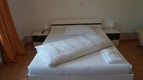 a bed with white sheets and pillows on it at Gasthof National in Langendorf