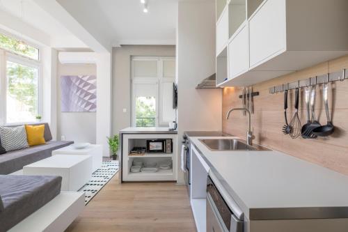 a kitchen with white cabinets and a sink at blueWaveplace - Contemporary Home in Center of Sofia in Sofia