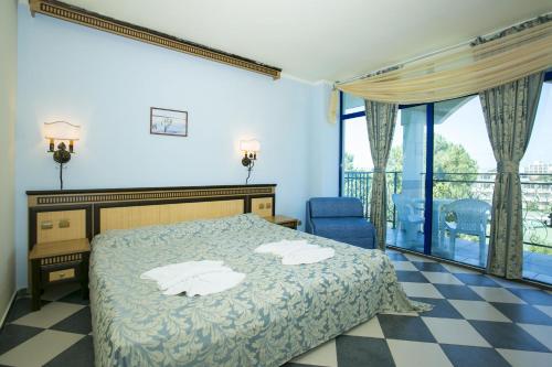 a hotel room with a bed and a balcony at Chaika Beach Resort in Sunny Beach