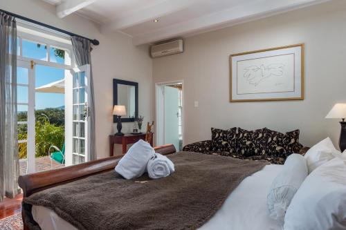 a bedroom with a large bed and a large window at Manor on the Bay in Gordonʼs Bay