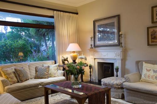 a living room with a couch and a fireplace at Carslogie House in Port Elizabeth