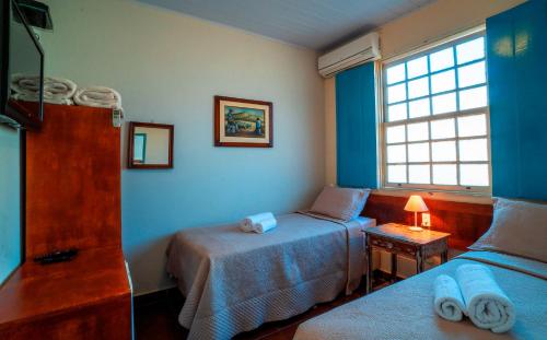 A bed or beds in a room at Pousada das Cavalhadas