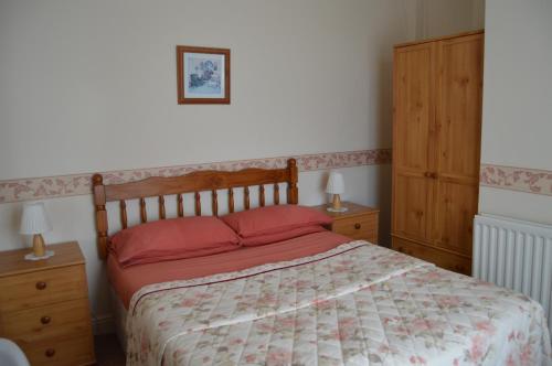 a bedroom with a bed with red pillows on it at Welcome Holiday Flats in Skegness