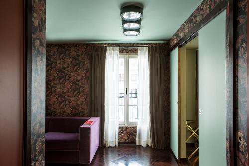 a living room with a purple couch and a window at Hôtel du Rond-point des Champs-Élysées - Esprit de France in Paris