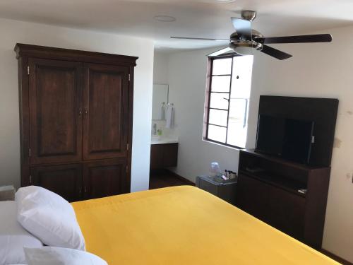 a bedroom with a ceiling fan and a television at Casa de Balcones in Garzón