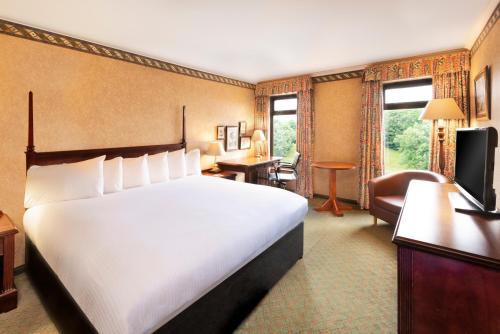 um quarto de hotel com uma cama e uma sala de estar em The Copthorne Hotel Cardiff em Cardiff