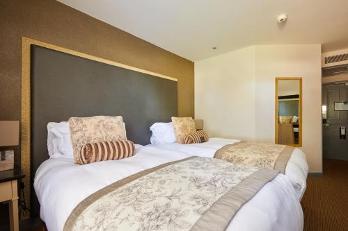 a hotel room with two beds and a large wall at WorldHotels Distinctive Woughton House Hotel in Milton Keynes