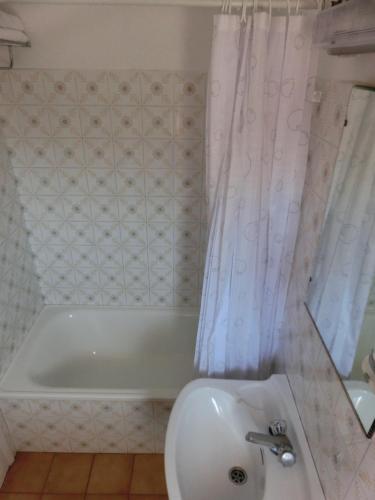 a bathroom with a tub and a toilet and a sink at Hotel Can Català in L'Escala