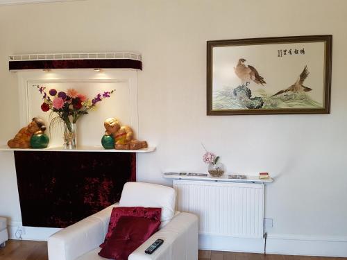 a living room with a white couch and a vase of flowers at Alba Guest House in Aberdeen