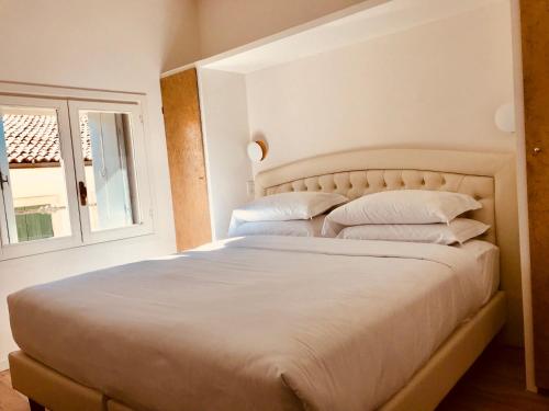a bedroom with a large bed with white sheets and pillows at Palazzo Otello 1847 Wellness & Spa in Vicenza