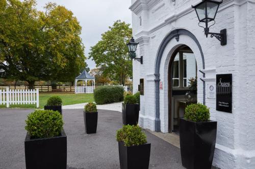 a group of potted plants in front of a building at WorldHotels Distinctive Woughton House Hotel in Milton Keynes