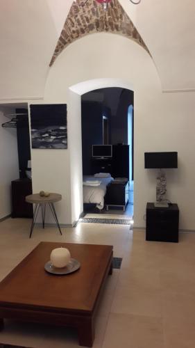 a living room with a table and a room with a bed at Oikia in Tolve