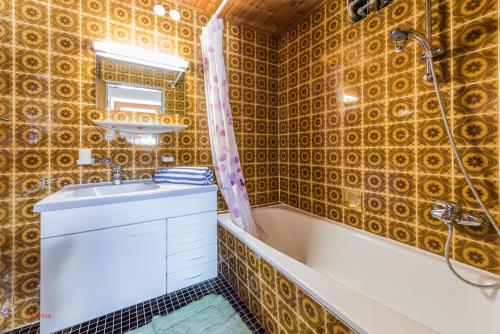 een badkamer met een bad, een wastafel en een bad bij Almliesl RAUR-437 in Rauris