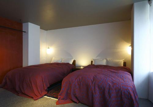a bedroom with two beds and two lamps at Malda Kyoto in Kyoto