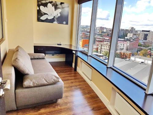 a living room with a couch and large windows at Most City Apart-Hotel in Dnipro