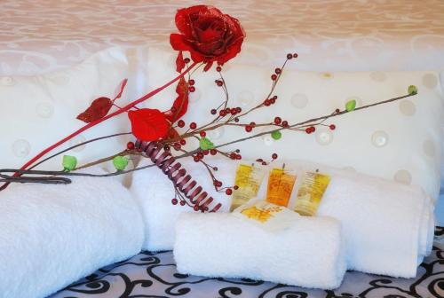 two white pillows with a red rose on top at Tranquil Guest House in Dundee