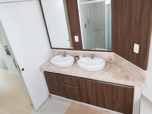 baño con 2 lavabos y espejo grande en Apartamento 101, en Itapema