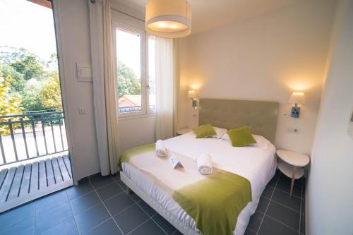 a bedroom with a bed with a large window at Lou Riou Village Vacances in Saint-Tropez