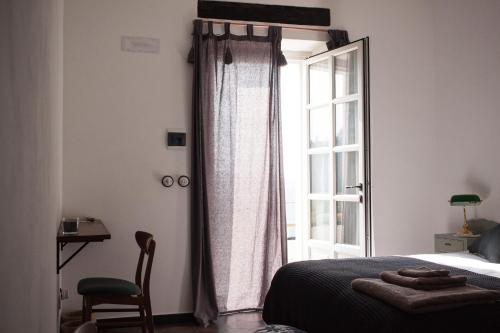 a bedroom with a bed and a window and a chair at B&B Mermaid n 16/a in Treiso