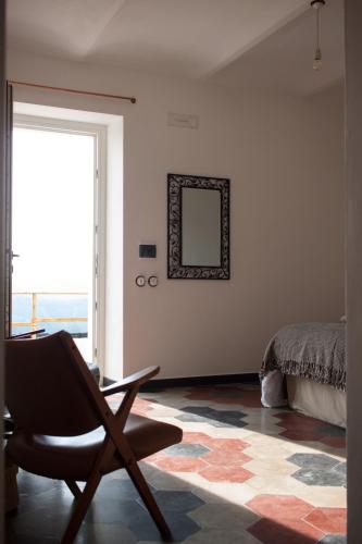 a chair in a room with a mirror and a bed at B&B Mermaid n 16/a in Treiso