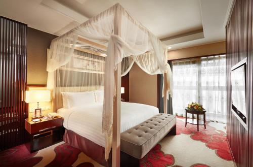 a bedroom with a canopy bed and a window at Beijing Hotel Minsk in Minsk