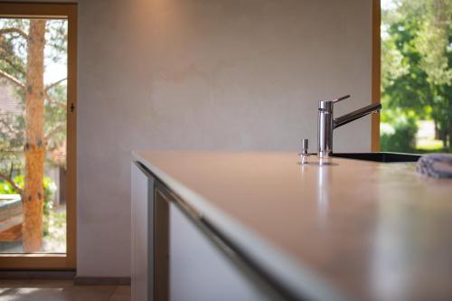 a kitchen counter with a faucet and a window at Le Holzberg et ses Suites in Osenbach