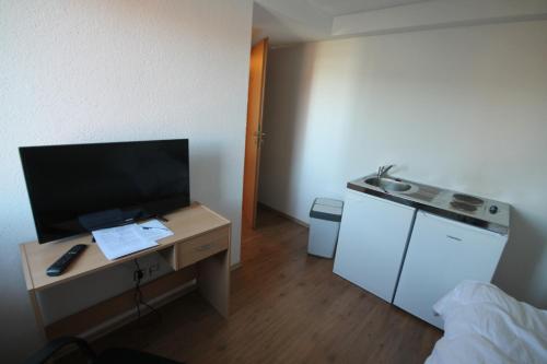 a room with a desk with a flat screen tv at Biberach-Riss-Zimmer-frei, Einzel-Zimmer Bad Küche in Birkenhard