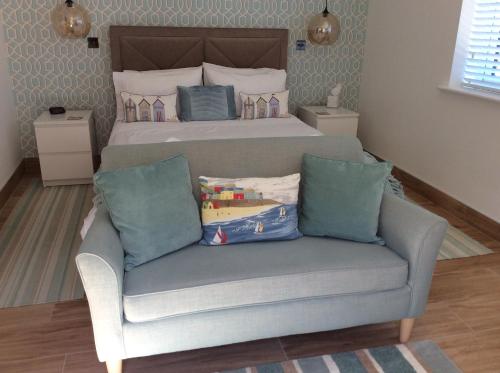 a bedroom with a bed and a couch with a bed at Cliff Top Studio in Barton on Sea