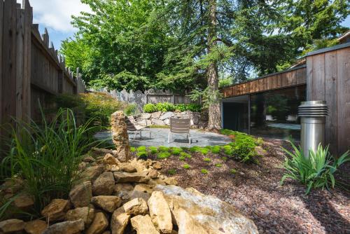 a garden with a stone wall and a patio at Le Holzberg et ses Suites in Osenbach
