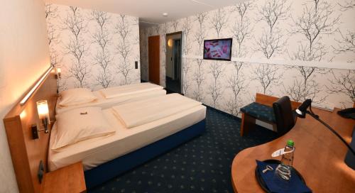ein Hotelzimmer mit einem Bett und einem Schreibtisch in der Unterkunft bonjour Tagungshotel Stuttgart-Gerlingen in Gerlingen