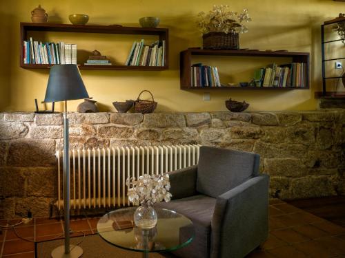 een woonkamer met een bank en een tafel met een lamp bij A Casa da Eira in Cerreda