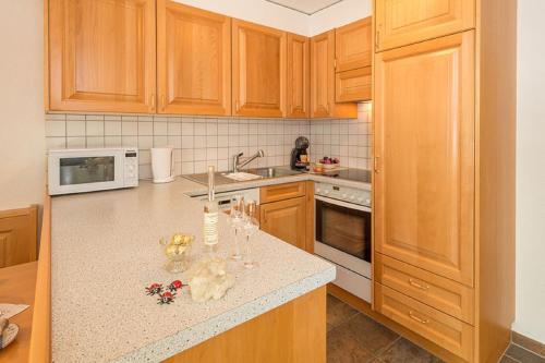 a kitchen with wooden cabinets and a counter top at Försterli Ost in Grächen