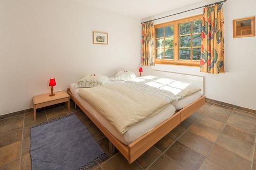 a bedroom with a large bed and a window at Försterli Ost in Grächen