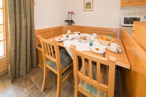 a kitchen with a table and chairs with food on it at Försterli Ost in Grächen