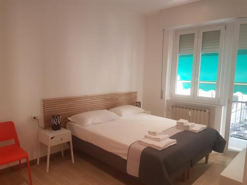 - une chambre avec un lit et une chaise rouge dans l'établissement Parfumerie 5 Terre, à La Spezia