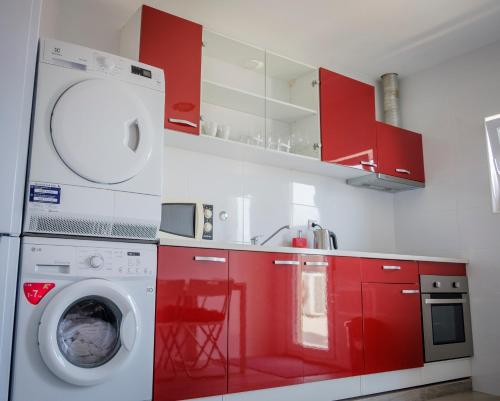 uma cozinha com armários vermelhos e uma máquina de lavar roupa em Maiahouse em Maia