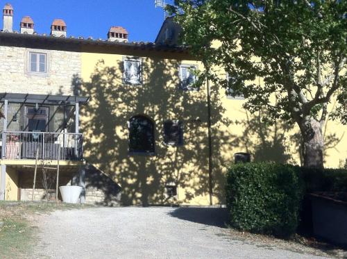 a yellow building with a tree in front of it at Tenuta dei Cavalieri in Molino del Piano