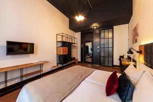 a bedroom with a large bed and a tv at Hotel Rum Budapest in Budapest