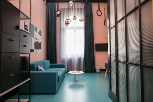a living room with a blue couch and a table at Hotel Rum Budapest in Budapest