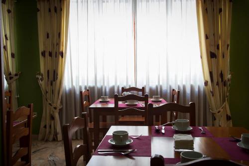a dining room with a table and chairs and a window at Hotel Castilla in Cáceres