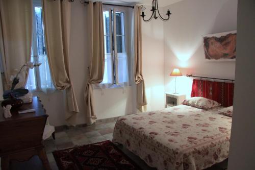 - une chambre avec un lit, des fenêtres et une lampe dans l'établissement Appartement Avec Patio Et Garage Centre Ville Et Plage, à Sanary-sur-Mer