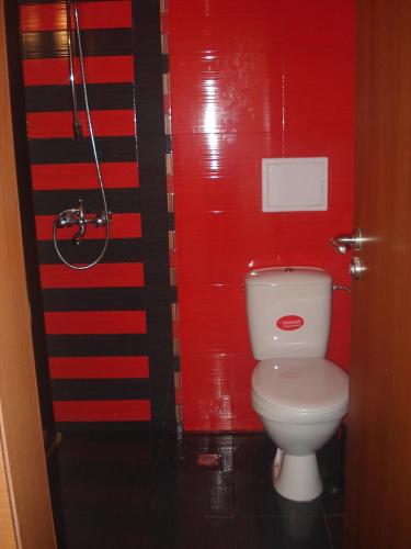 un bagno con un water e una parete rossa di Villa Rouge a Sozopol